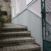 pinke Hausfassade und graue Steinstufen