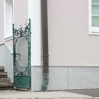 grüner Metalltor und pinke Hausfassade